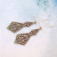 Beautiful, ox solid brass, filigree drops hang from 14K gold filled ear hooks/wires. Open back.Very simple, yet elegant, and they go any where, any time.Total earring length is approx. 2".-All components of my jewelry are made without lead and nickle.-All sterling silver is 925, nothing less. It is also tested on a regular basis for strength.-All rhodium/silver/gold/bronze/gunmetal plates are quality pieces.-Best of all, since I am particular about my components, I love to shop for supplies and Antique Gold Chandelier Earrings In Brass, Victorian Gold Chandelier Earrings In Brass, Victorian Gold Filigree Chandelier Earrings, Ornate Brass Earrings With Ear Wire, Antique Gold Brass Earrings With Intricate Design, Vintage Antique Gold Earrings With Intricate Design, Bronze Filigree Brass Earrings, Vintage Bronze Filigree Earrings, Vintage Filigree Chandelier Earrings As Gift