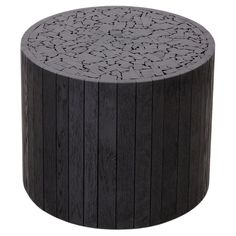 a round wooden table with black paint on the top and wood graining around it