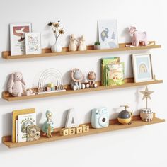 three wooden shelves filled with toys and books