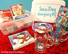 a table topped with cups and plates covered in snowman napkins next to an ice box