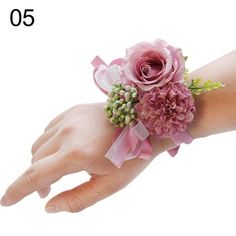 a woman's hand with a pink wrist corsage