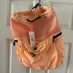 an orange handbag hanging on a white door with a price tag attached to it