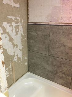 a bathtub in a bathroom that is being remodeled with white paint on the walls