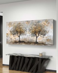 an abstract painting hangs on the wall above a console table