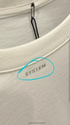 a white shirt with the word system written on it and a blue circle in the middle