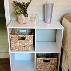 a white shelf with wicker baskets on it