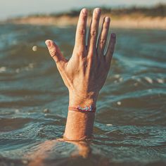 a person's hand in the water with their wrist resting on top of it