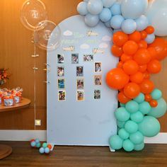 an arch made out of balloons with pictures on the front and back wall, along with other decorations