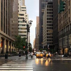 people crossing the street in front of tall buildings