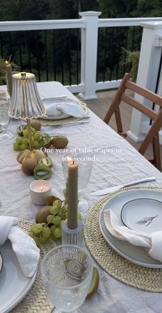 the table is set with plates, silverware and fruit on it for an elegant dinner