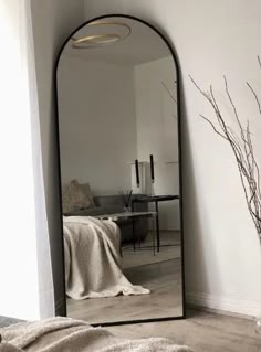 a large mirror sitting on top of a wooden floor