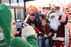 a group of people taking pictures with santa clause