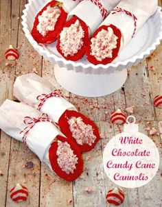 white chocolate candy canes in a bowl on a wooden table with red candies