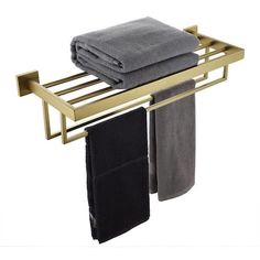 two towels are hanging on a gold towel rack with black and gray towels in it