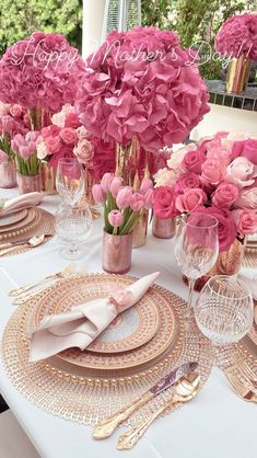 a table set with pink flowers and gold place settings for a formal dinner or bridal party