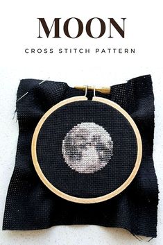 the cross stitch pattern shows a monkey's head on a black cloth with gold trim