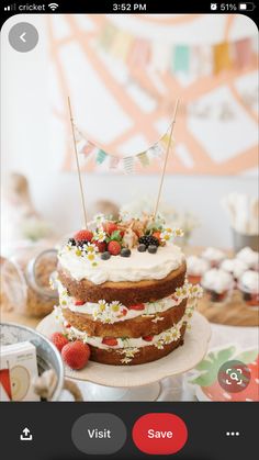 a cake sitting on top of a white plate topped with berries and strawberries next to a flag