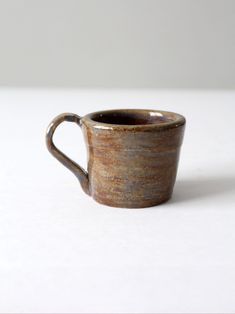 a brown cup sitting on top of a white table