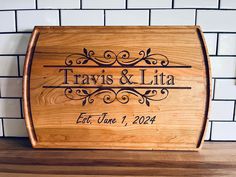 a wooden cutting board with the name travis and lila engraved on it