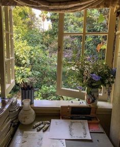 an open window in a room filled with lots of plants and papers on top of a table