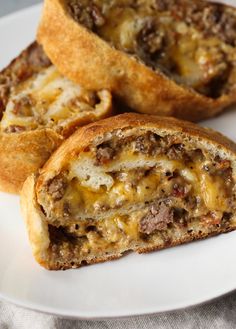 two pieces of bread with cheese and meat inside on a plate