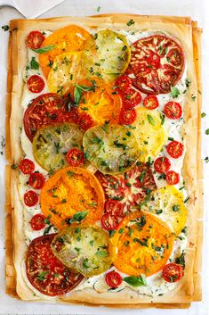 a square pizza with tomatoes, cheese and herbs on the toppings is ready to be eaten