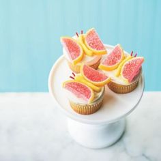 some cupcakes with fruit on them sitting on a plate