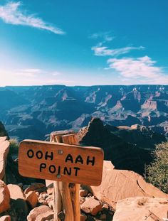 a wooden sign sitting on the side of a mountain