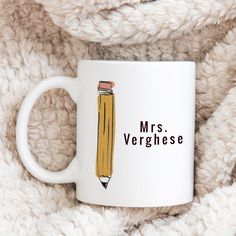 a white coffee mug with a pencil drawn on it and the words mrs verghese