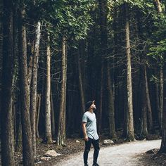 a man standing in the middle of a forest