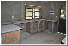 an empty room with concrete counter tops and bars