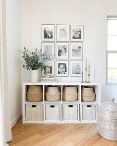 a white shelf with baskets and pictures on it