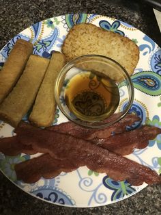 a plate with bacon, bread and butter on it