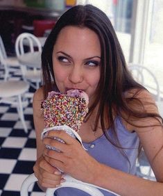 a woman eating a donut with sprinkles on it