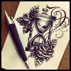 a drawing of an hourglass with roses and leaves on paper next to a pen