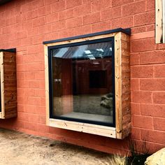 a red brick building with two windows on each side and one window in the middle