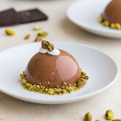 three desserts on white plates with chocolate and pistachio