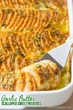 a close up of a casserole in a white dish with a spatula