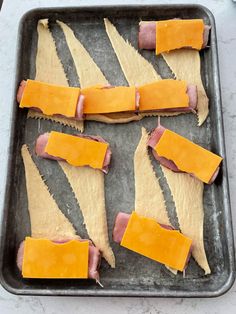 several slices of ham and cheese on a baking sheet