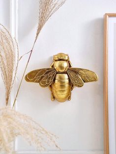 a golden bee is mounted on the wall