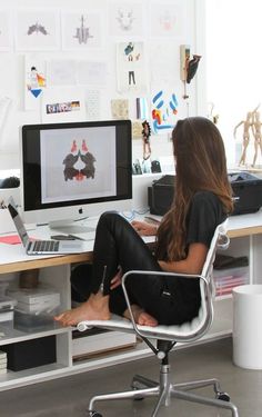 a woman sitting at a desk with a computer