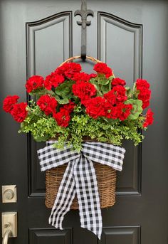 red carnations in a basket tied with a black and white checkered ribbon