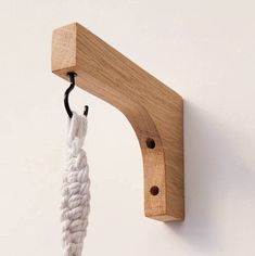 a wooden hook with a white rope hanging from it's end on a wall