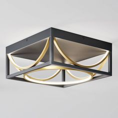 a modern ceiling light with an unusual design and gold accents on the top, suspended from a metal frame