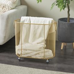 a baby crib next to a potted plant on the floor in a living room