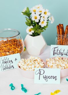 popcorn, marshmallows and other snacks are on the table for guests to eat