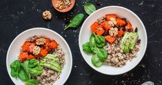 two white bowls filled with food on top of a black table next to an orange and green pepper