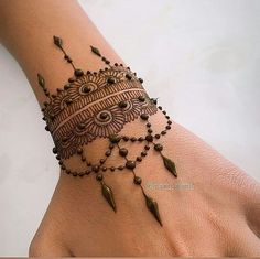 a woman's hand with henna tattoos on it