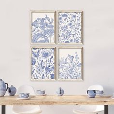 three blue and white floral prints hanging on the wall above a dining room table with chairs