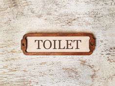 a wooden sign that says toilet on it